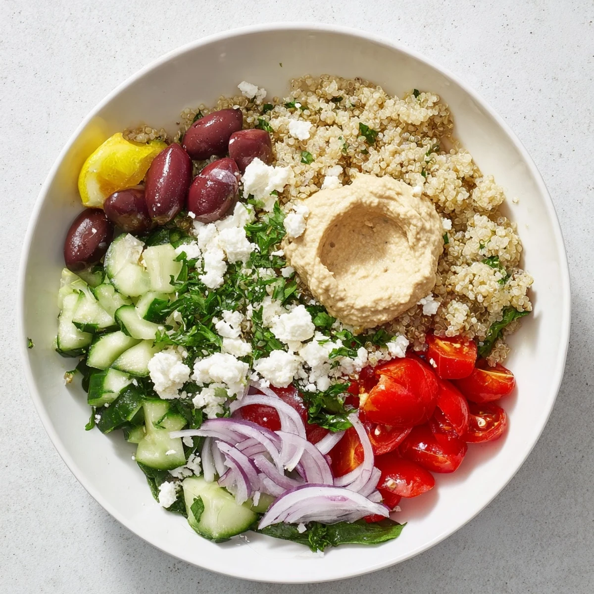 Fluffy quinoa in a colorful Mediterranean Quinoa Bowl with fresh vegetables and creamy hummus.