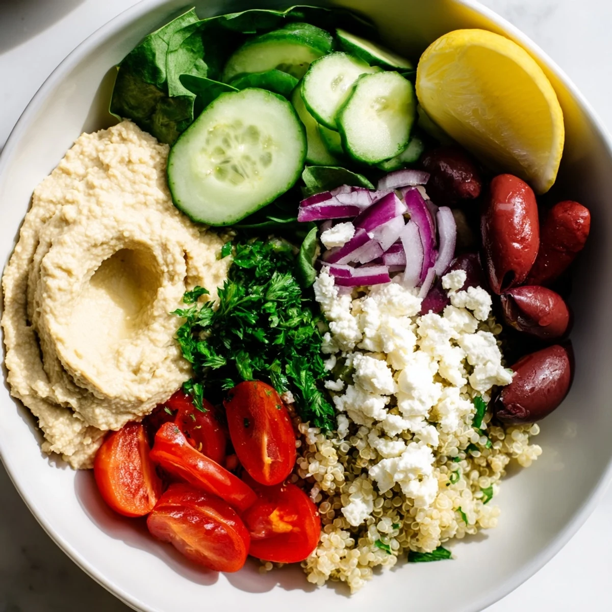 Ready-to-eat Mediterranean Quinoa Bowl with hummus, feta, and a bright lemon and herb dressing.