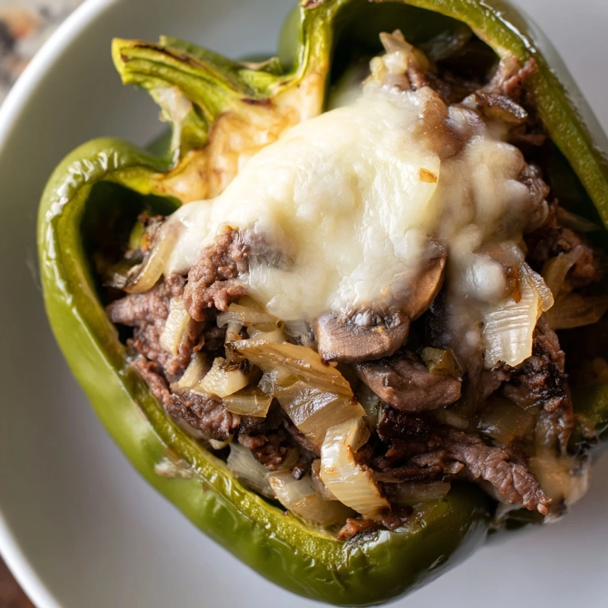Golden-brown Beef Philly Cheesesteak Stuffed Peppers filled with sautéed beef and onions, topped with melted provolone.