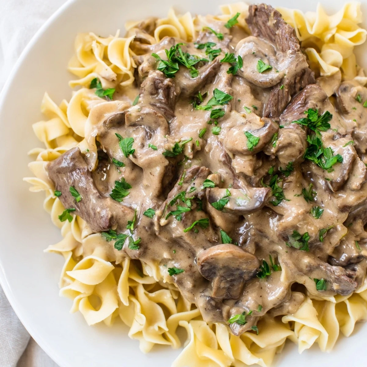 Golden sautéed beef strips and mushrooms smothered in a creamy, rich stroganoff sauce, ready to serve hot.