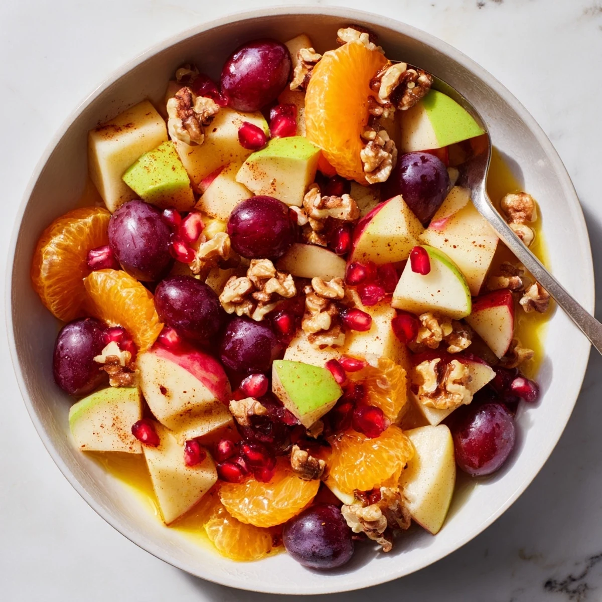 Freshly prepared Winter Snack Fruit Mix tossed in orange-cinnamon dressing, served in a rustic bowl.