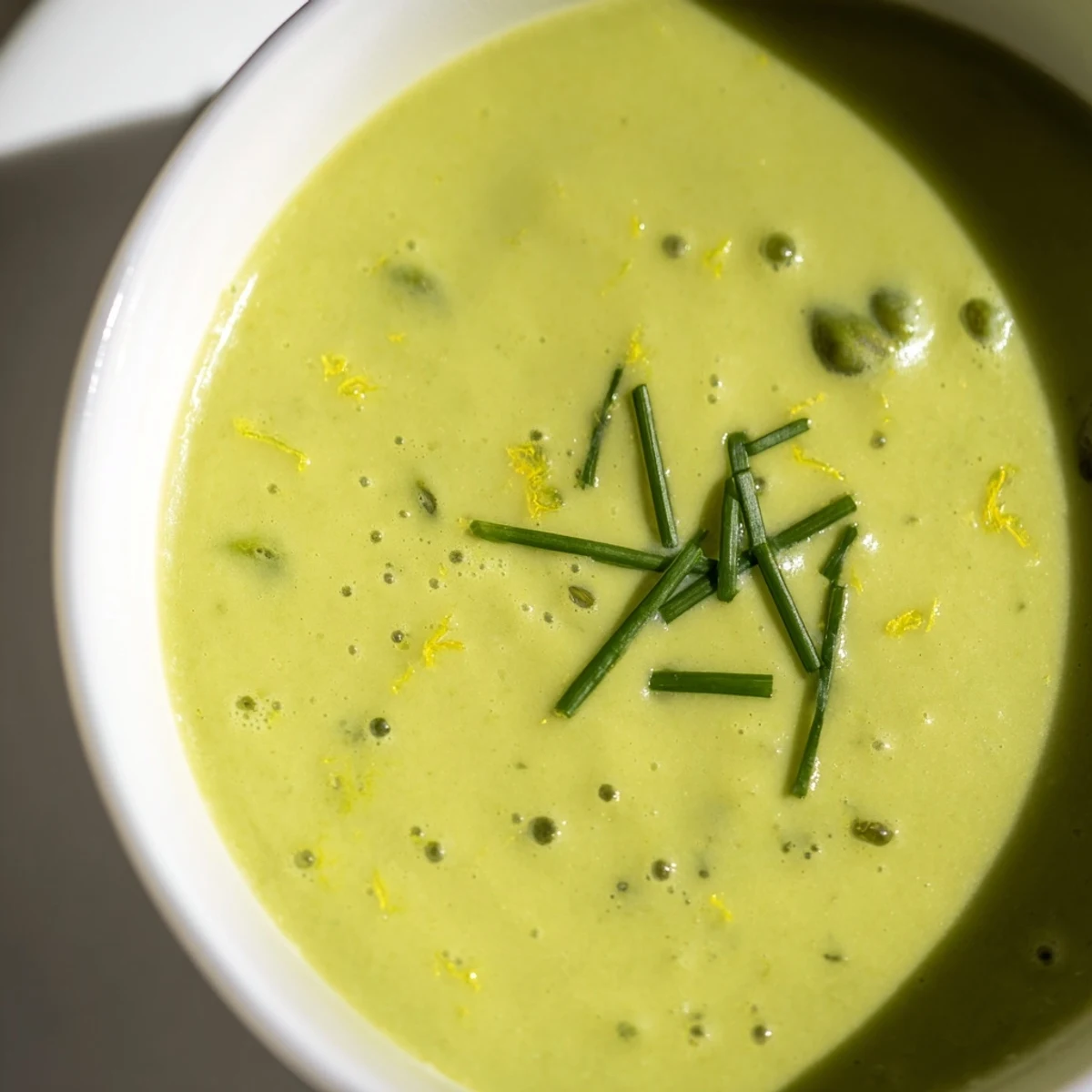 Creamy Asparagus Soup with Lemon in a rustic bowl, topped with herbs and ready for a spring appetizer.