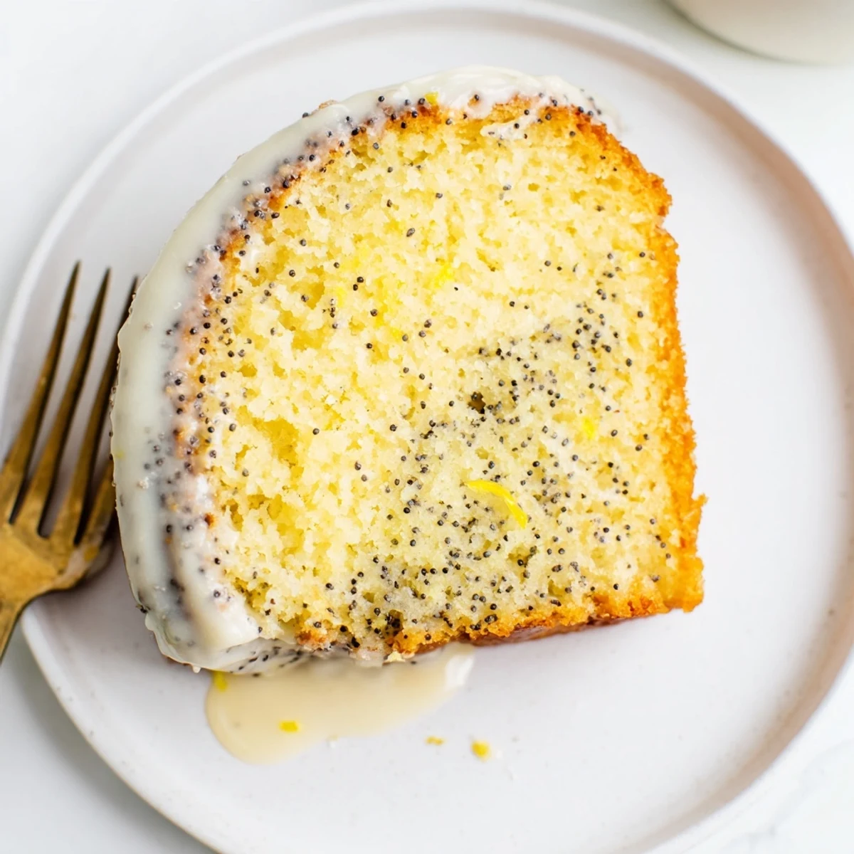 Golden slices of Lemon Poppy Seed Bundt cake are arranged on a plate, ready for an afternoon tea service.
