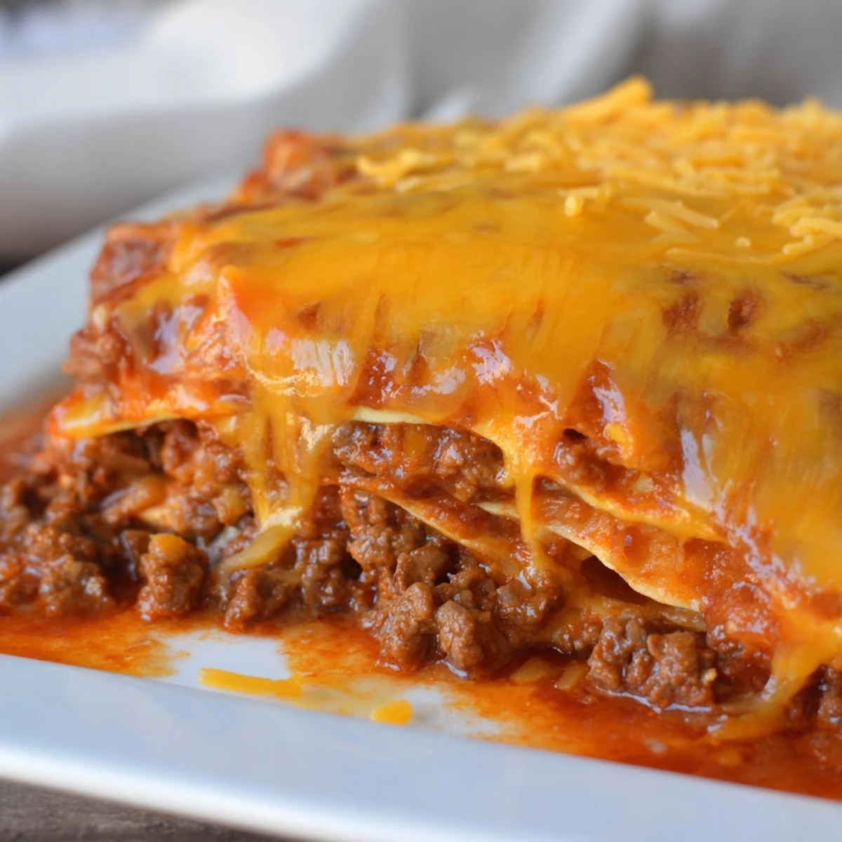 A close-up shows the Beef Enchilada Casserole with fresh cilantro and diced tomatoes as garnish.
