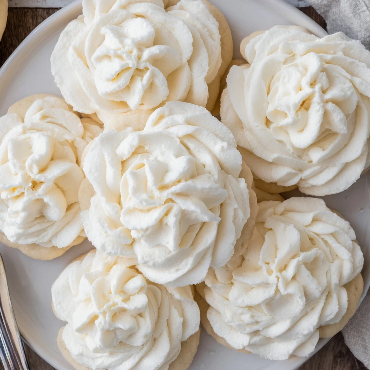 Close-up of Easy Sugar Cookie Frosting on decorated sugar cookies, showing a smooth texture with a slight crust.