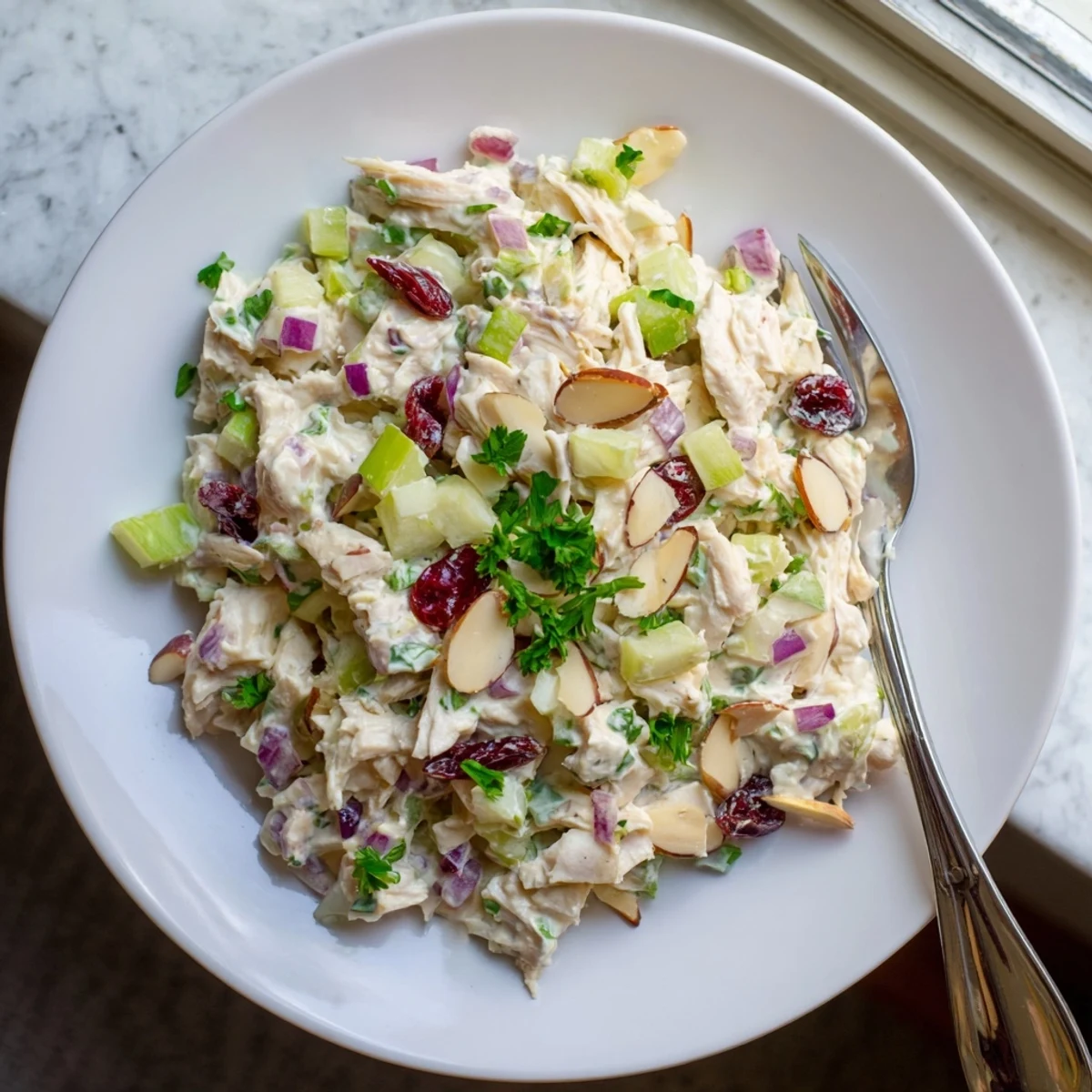 Healthy Greek yogurt rotisserie chicken salad served on whole grain crackers with sliced almonds