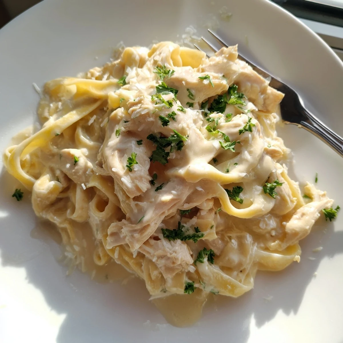 Creamy Crock Pot Chicken Alfredo with tender shredded fettuccine in rich white sauce