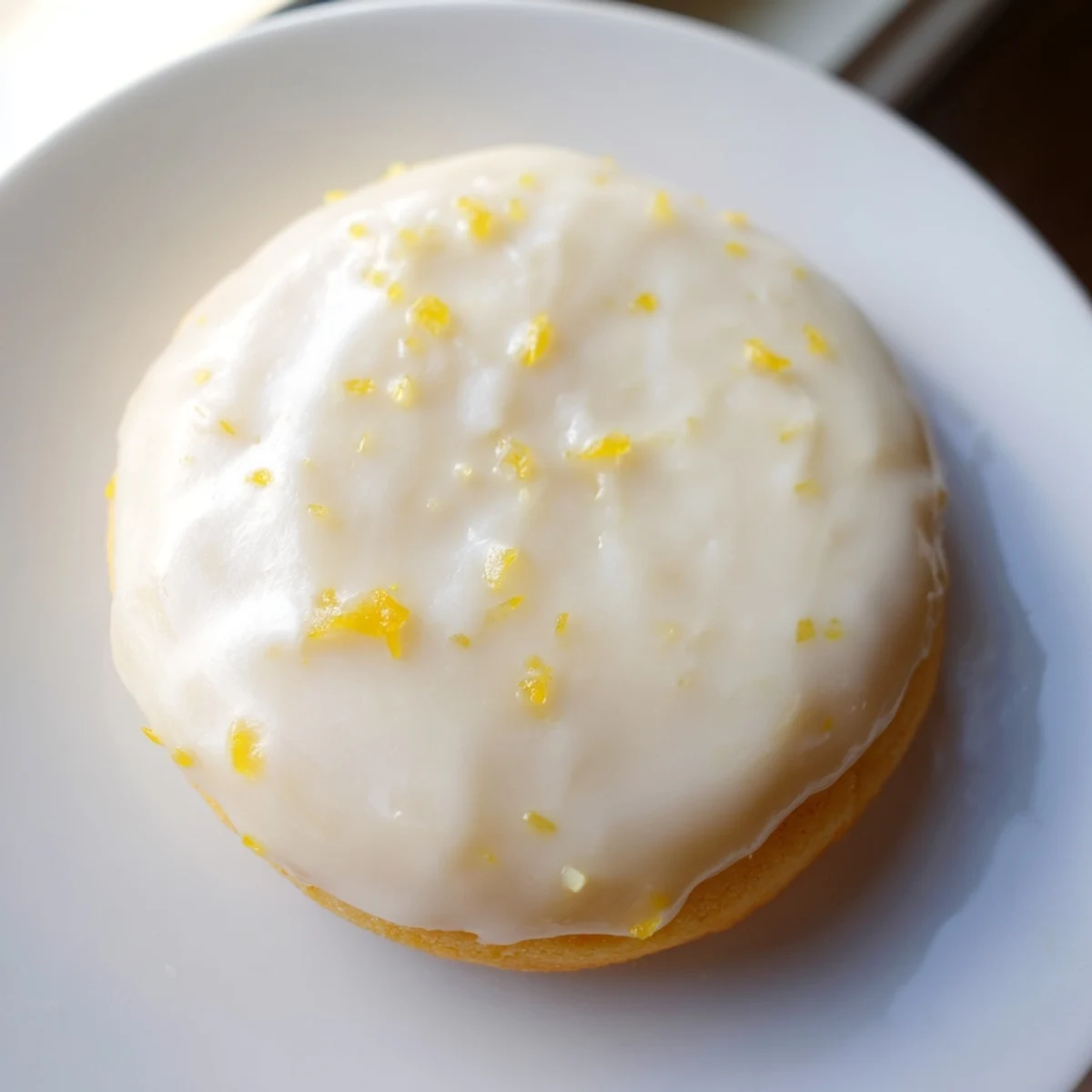 Golden lemon frosted cookies topped with zesty icing and fresh lemon zest sprinkles