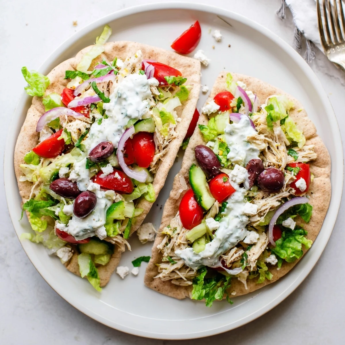 Golden slow-cooked chicken stuffed in warm pita with crisp veggies and cool tzatziki sauce