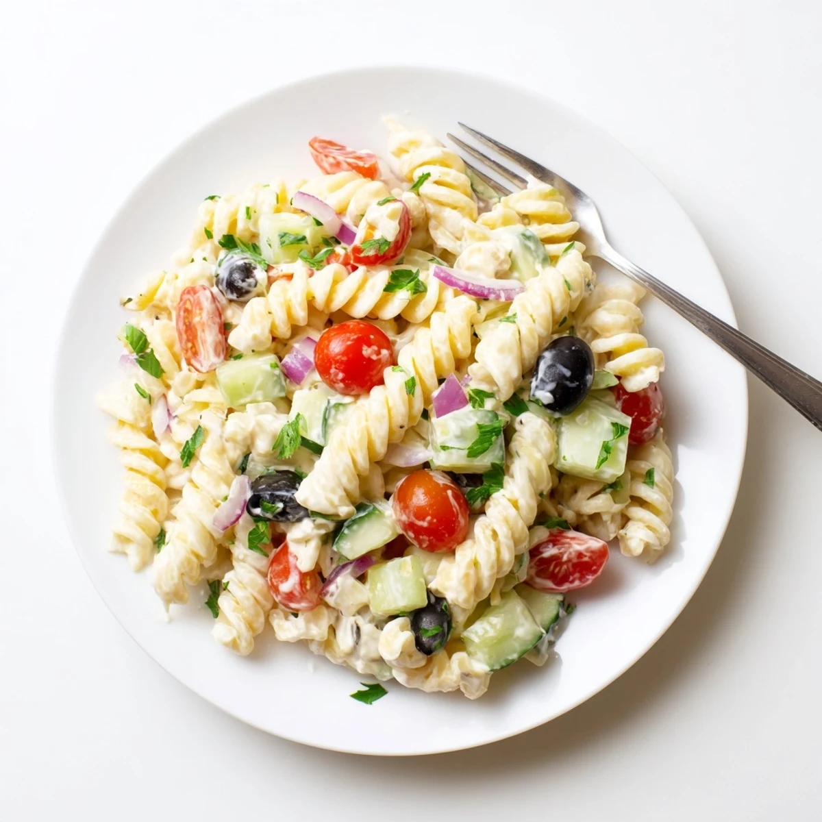 Colorful Mediterranean cottage cheese pasta salad loaded with cherry tomatoes, cucumber, and olives in a large serving bowl.