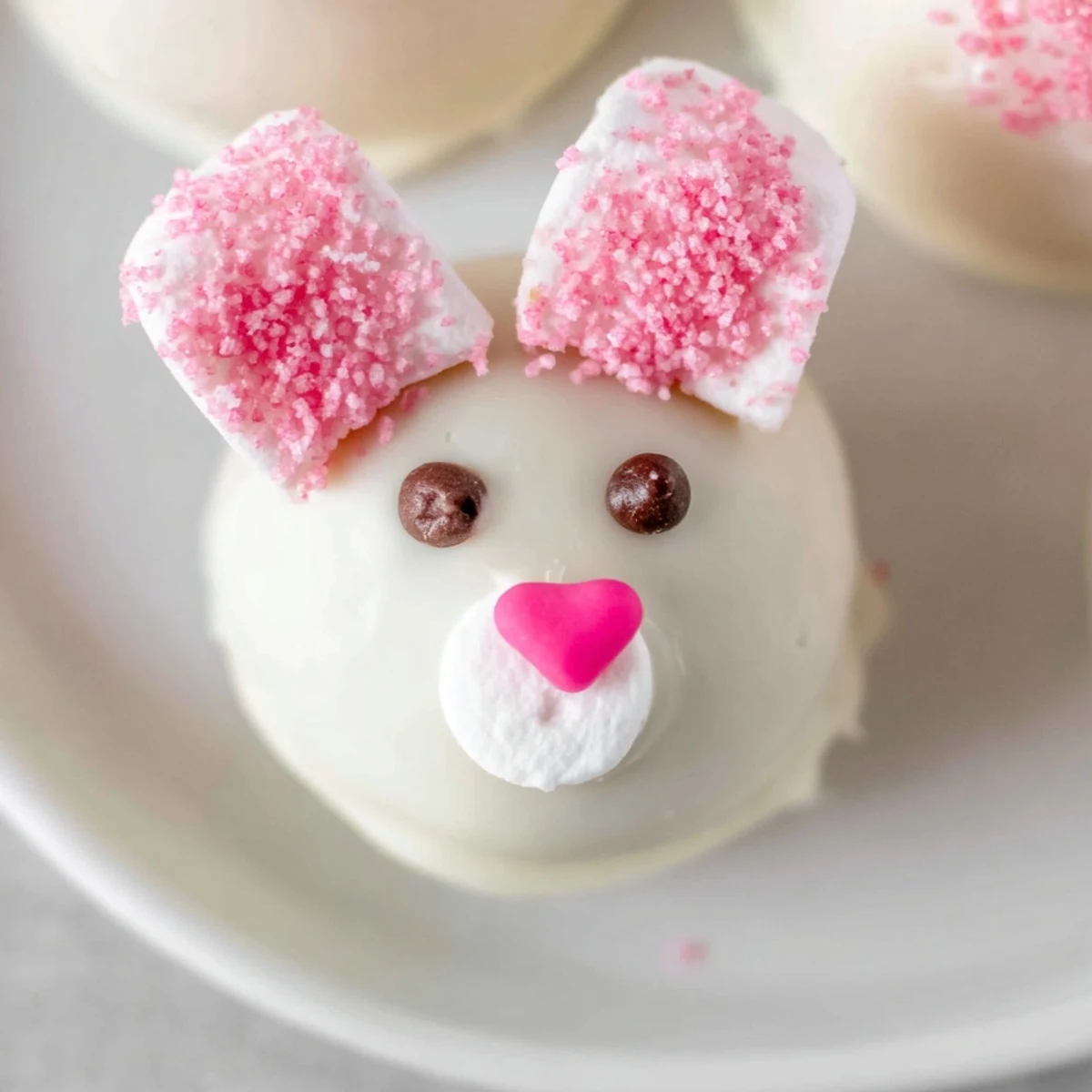 Adorable Bunny Oreo balls dipped in smooth white chocolate with pink marshmallow ears and cute candy faces.
