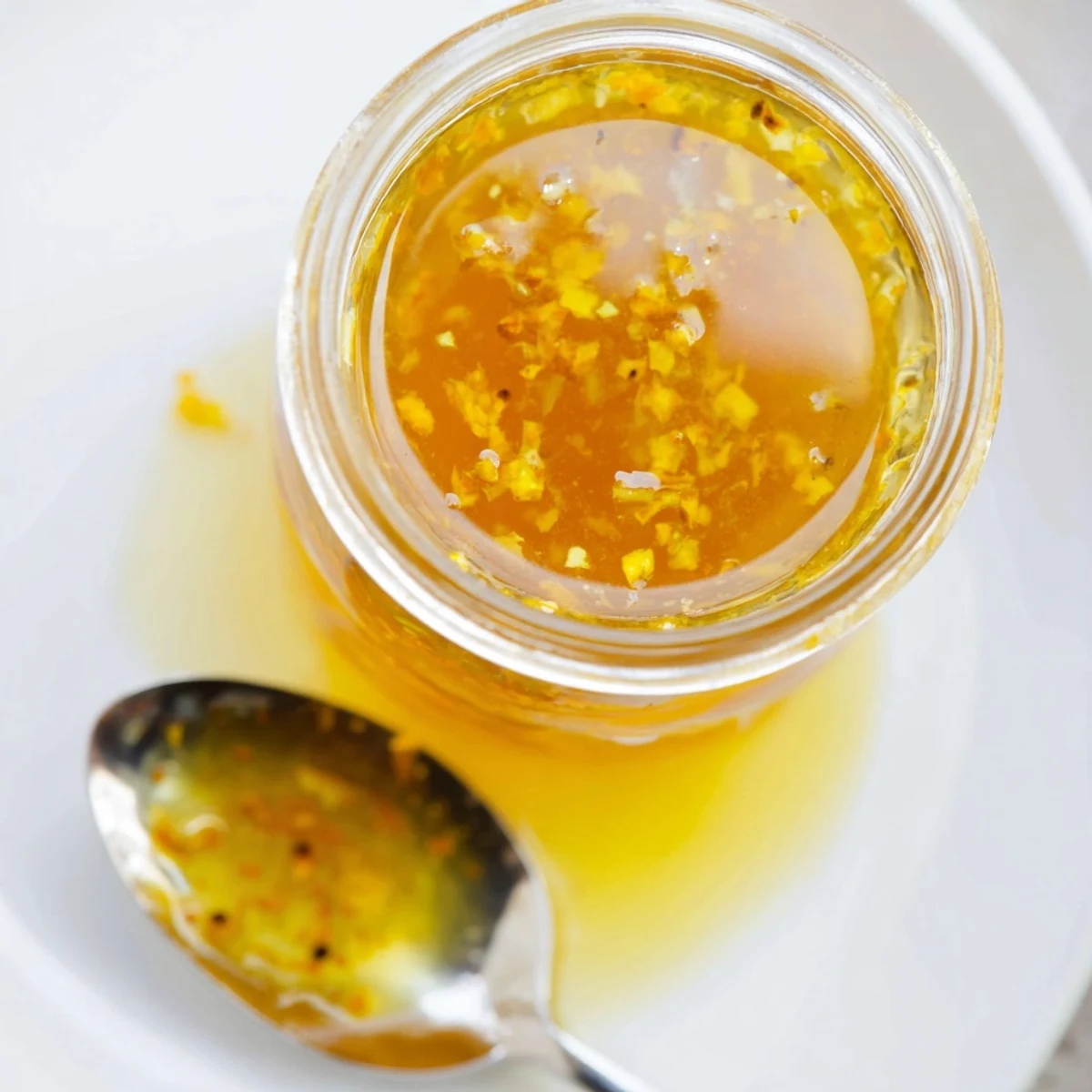 Tangy citrus vinaigrette pooled over roasted vegetables on a white ceramic serving platter