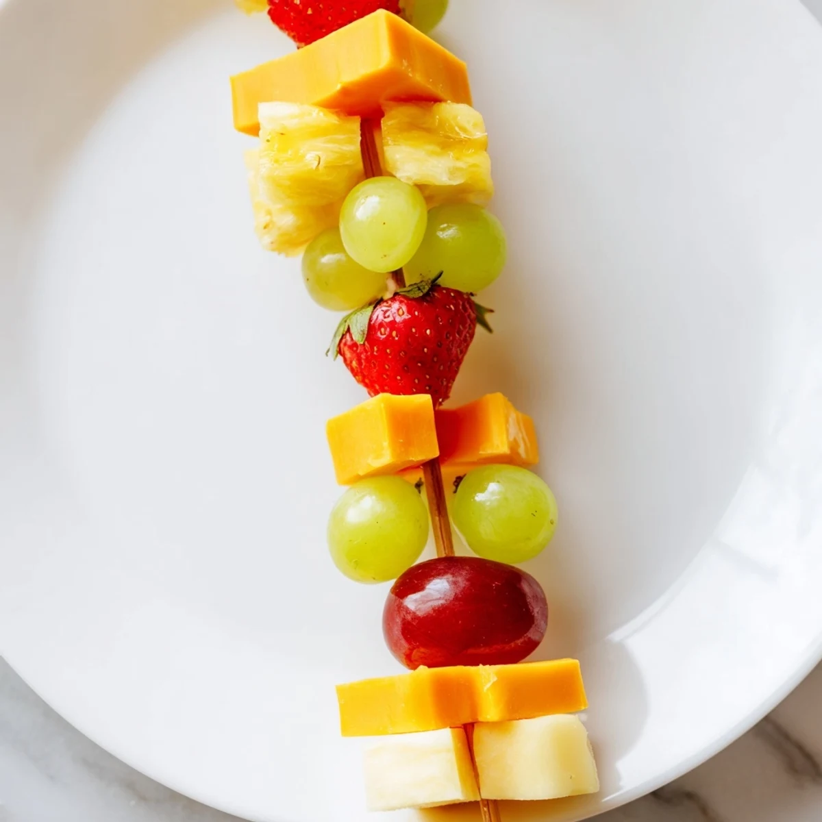 Fresh fruit and cheese kabobs featuring alternating pineapple strawberries and creamy Monterey Jack pieces