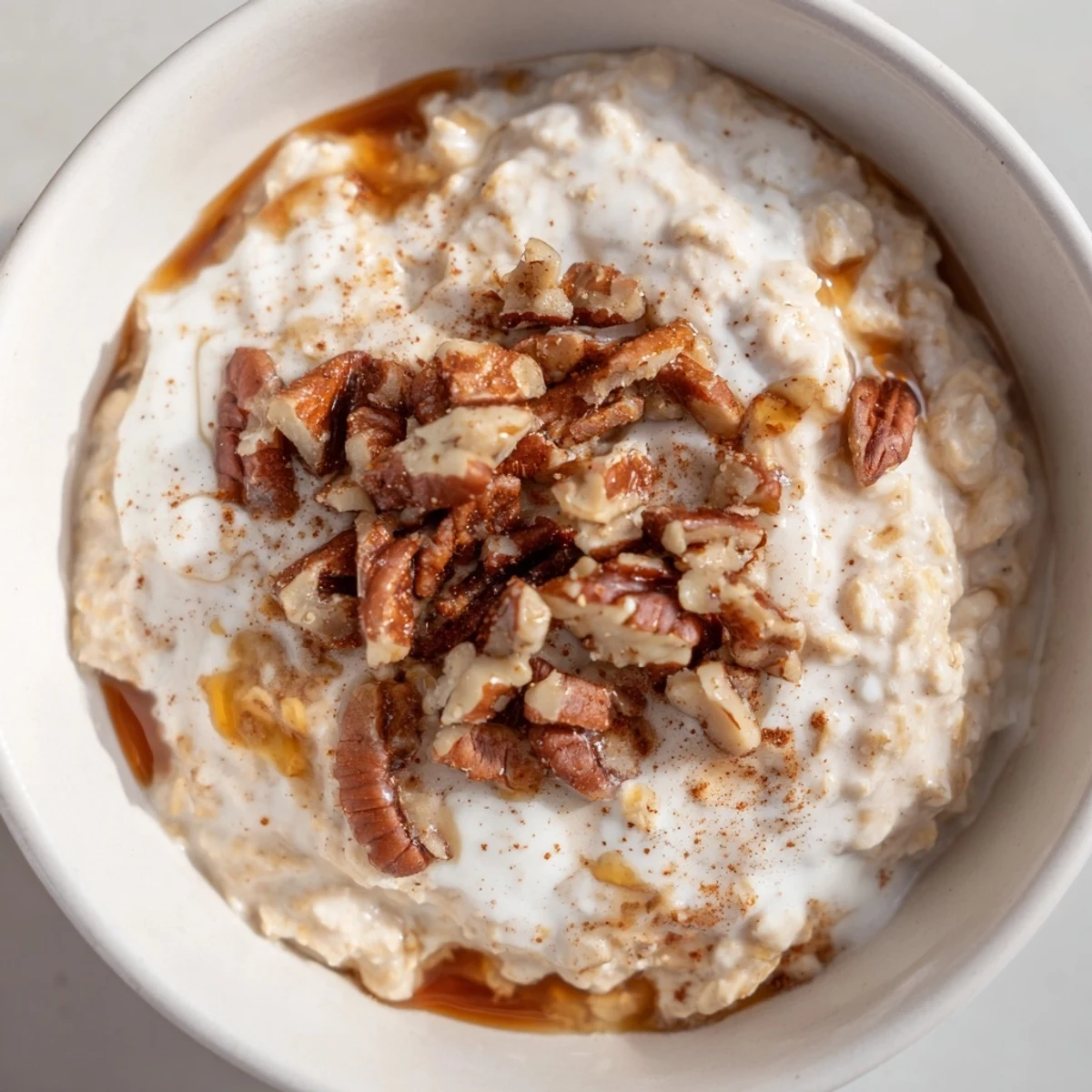Maple cinnamon pecan overnight oats topped with toasted nuts and a drizzle of sweet maple syrup