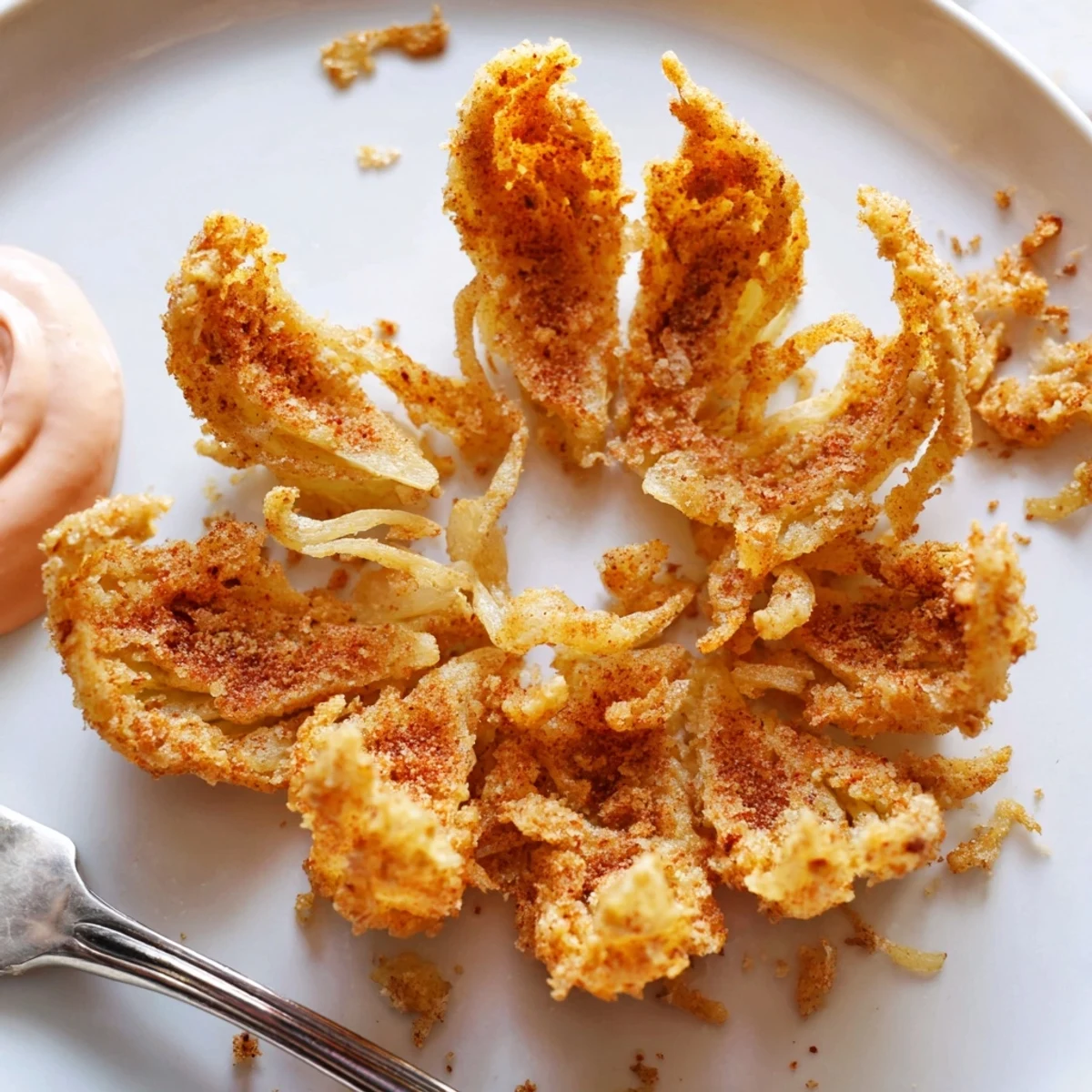 Golden crispy mini bloomin onions served with spicy horseradish dipping sauce