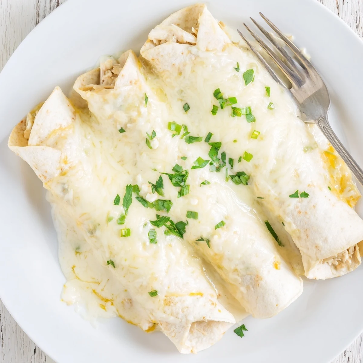 Sliced cilantro-topped White Rotisserie Chicken Enchiladas served warm with rice