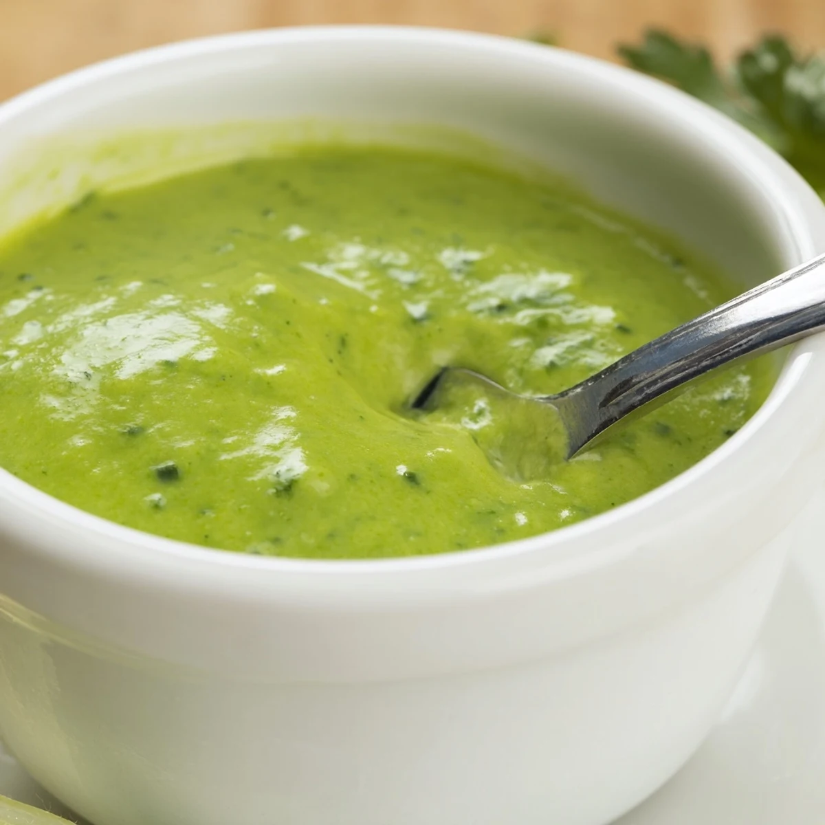 Homemade Peruvian aji verde sauce featuring fresh cilantro, jalapeños, and lime in a glass jar