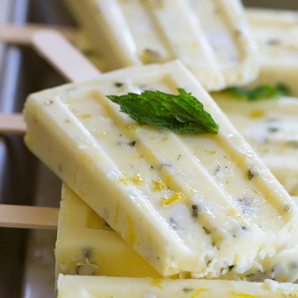Frozen zesty lemon yogurt popsicles dripping with creamy texture and fresh citrus zest