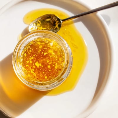 Creamy emulsified citrus vinaigrette in a glass jar with fresh orange and lemon slices