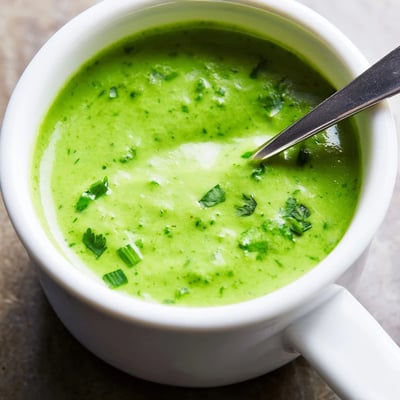 Vibrant green aji verde Peruvian sauce drizzled over grilled chicken and roasted vegetables